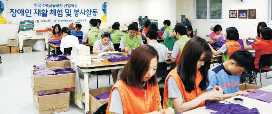 주택금융공사 임직원들이 22일 부산시 부산진구 성지로길에 있는 신애재활원에서 장애인들과 함께 장애인 재활 체험 및 봉사활동을 하고 있다.     주택금융공사 제공